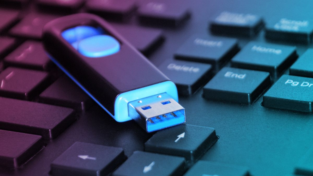 flash drive laying on top of a laptop computer's keyboard