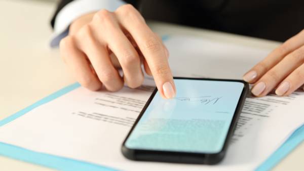 Person signing a document on their smartphone