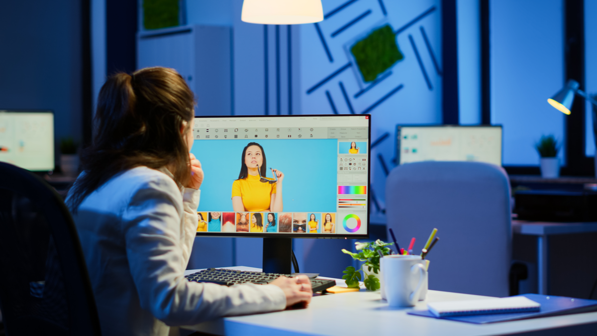 A woman working at a computer, converting image files.