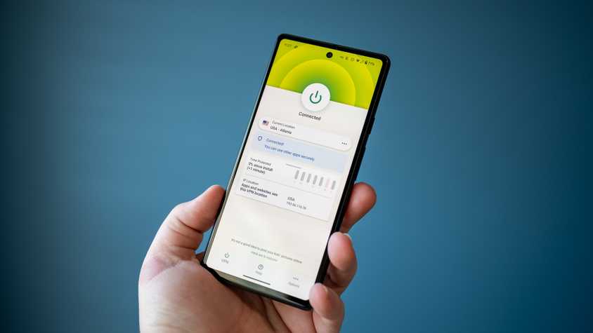 Homem segurando um telefone com um aplicativo VPN mostrando o status 'conectado'.