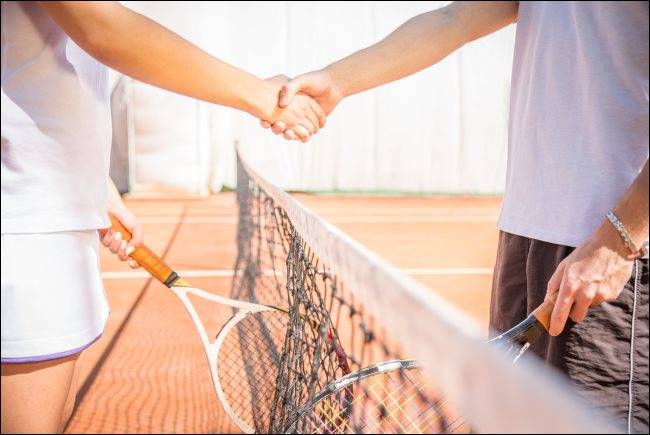 Two players shaking hands at a tennis court