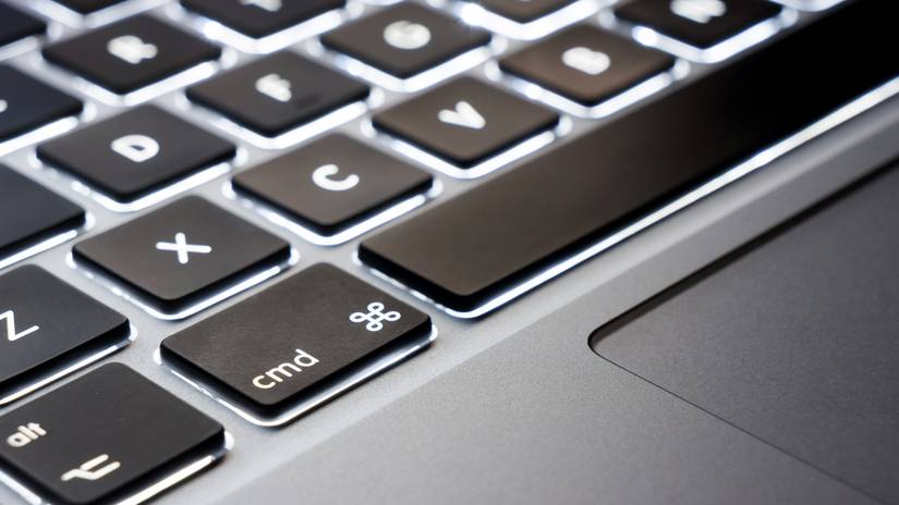 A MacBook user using keyboard shortcuts to copy and paste text on Mac