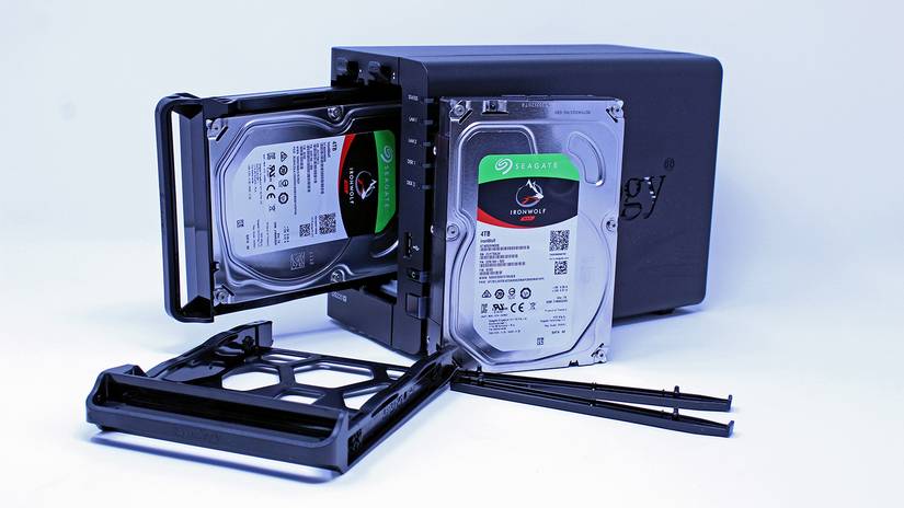 The DS220+ NAS with one hard drive removed, showing snap trays.