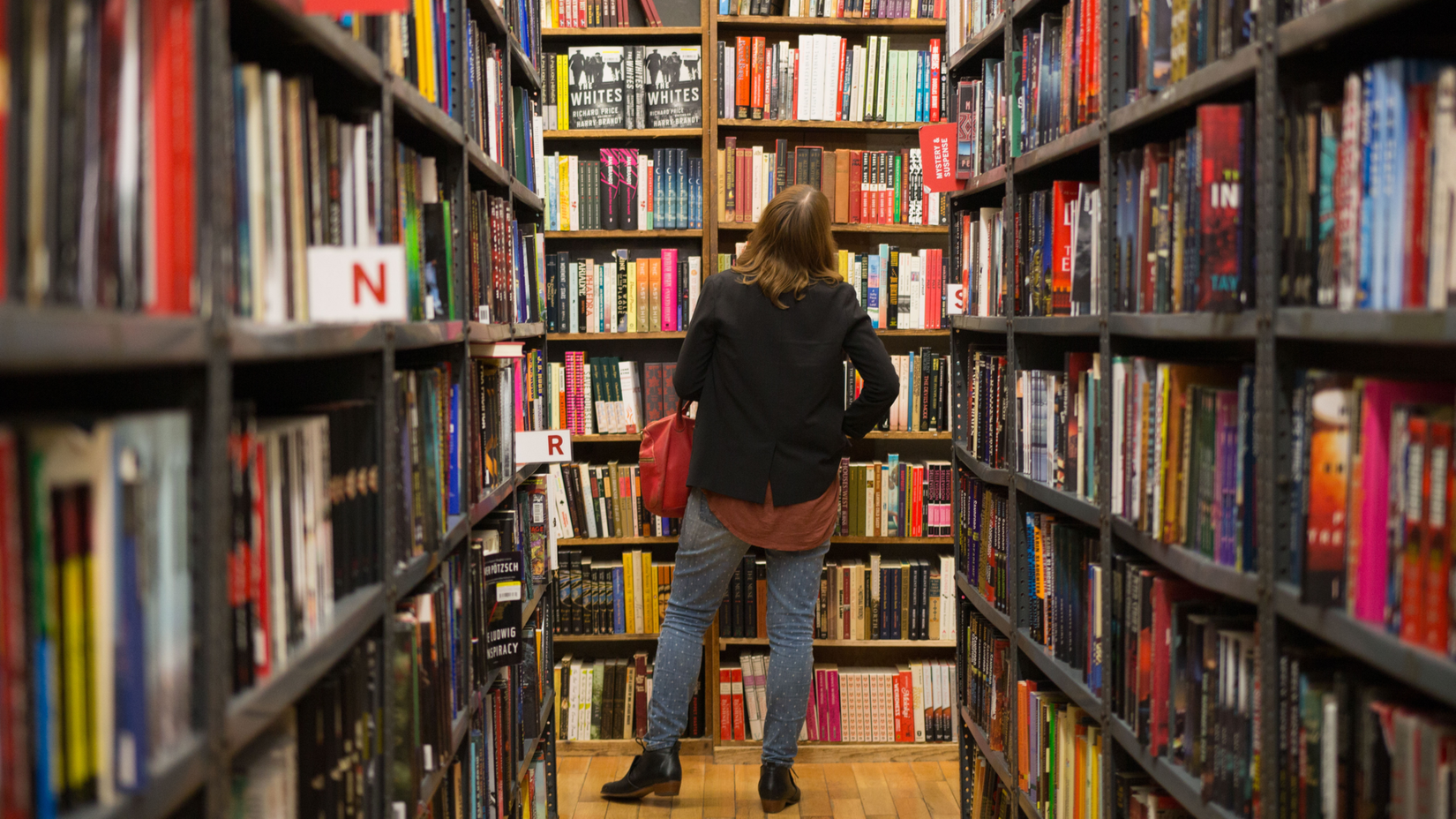 A woman looking at books in a library.