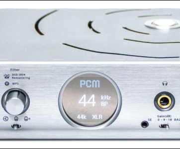 An external DAC with silver chassis and circular LCD display.