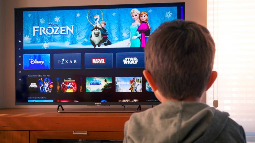 A kid watching Disney+ on a TV.