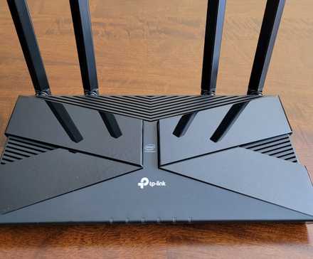 An overhead shot of the tp-link archer ax50 router by itself on a wooden table (1)