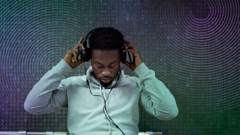 Man putting on headphones with multicolor audio waves in background