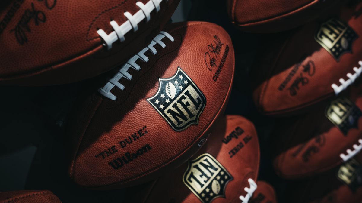 NFL footballs lined up against wall