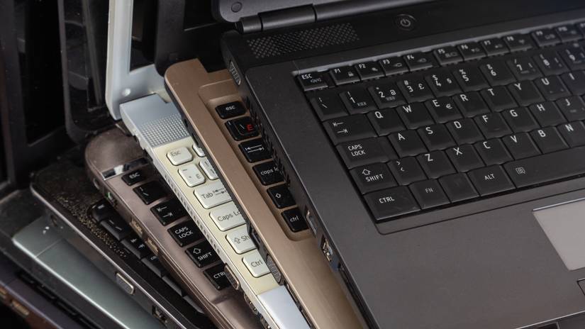 Stack of dusty used laptops.