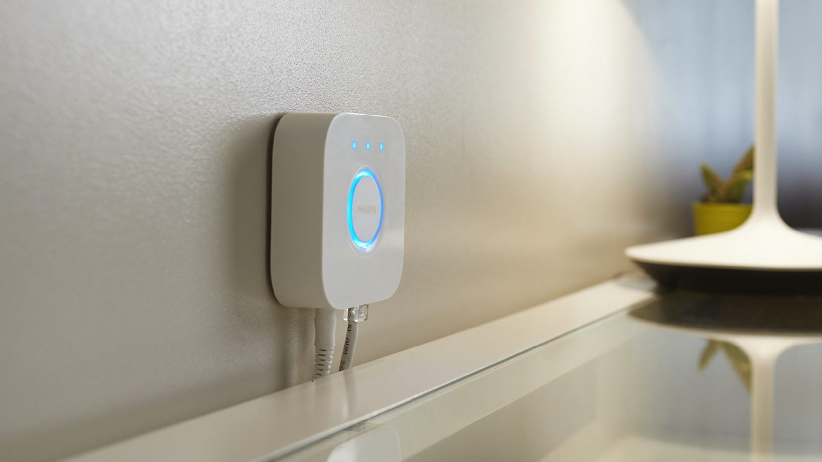The Philips Hue bridge mounted to a wall.