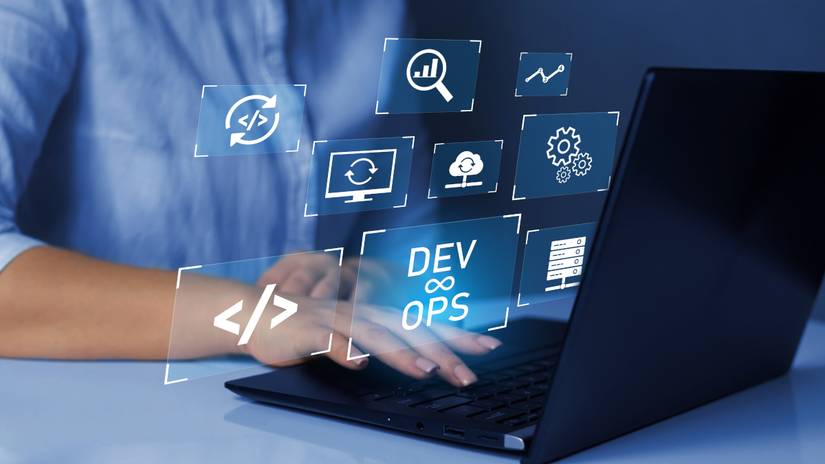 Foto de uma pessoa digitando em um laptop com letras DevOps parecendo voar para fora da tela