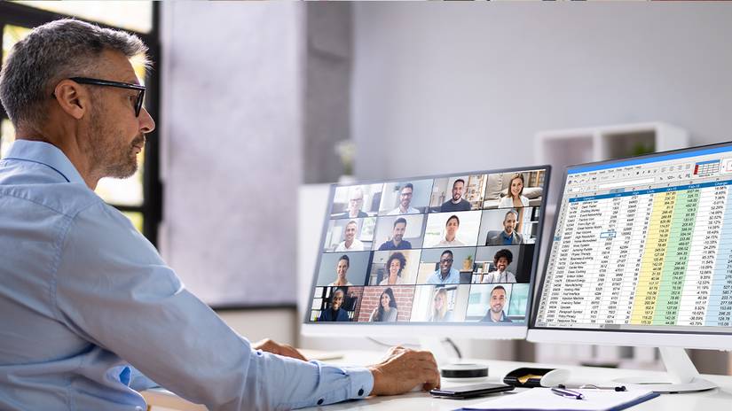 A man looking sat spreadsheets in the workplace.