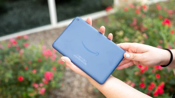 Person holding a blue Amazon Fire 7 (2022) tablet