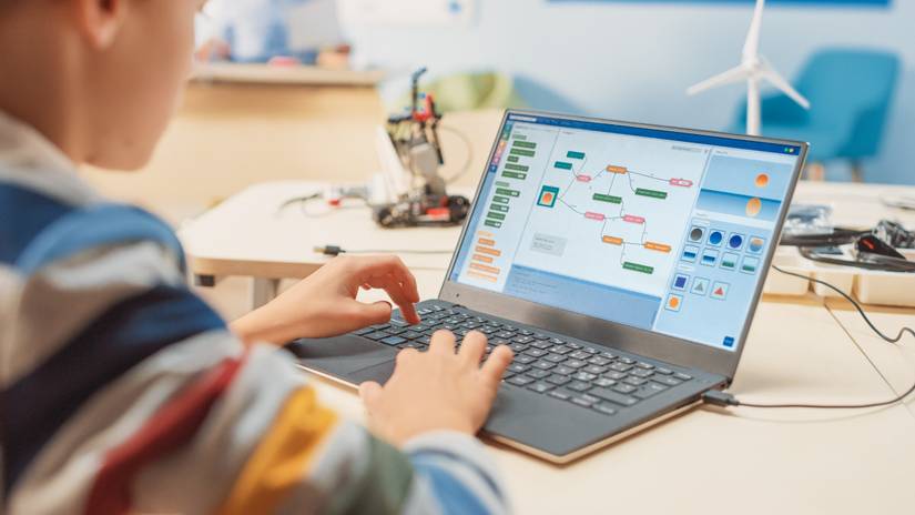 A kid programming with a laptop.