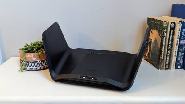 The Netgear Nighthawk RAX300 router on a bookshelf.