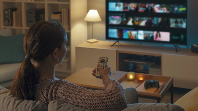 A scene over the shoulder of a woman travels in the broadcast application on TV.