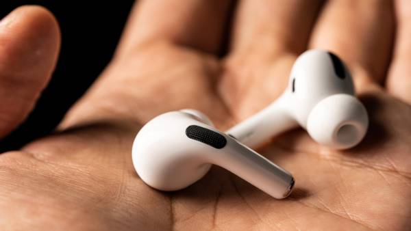 A pair of AirPods in a person's hands