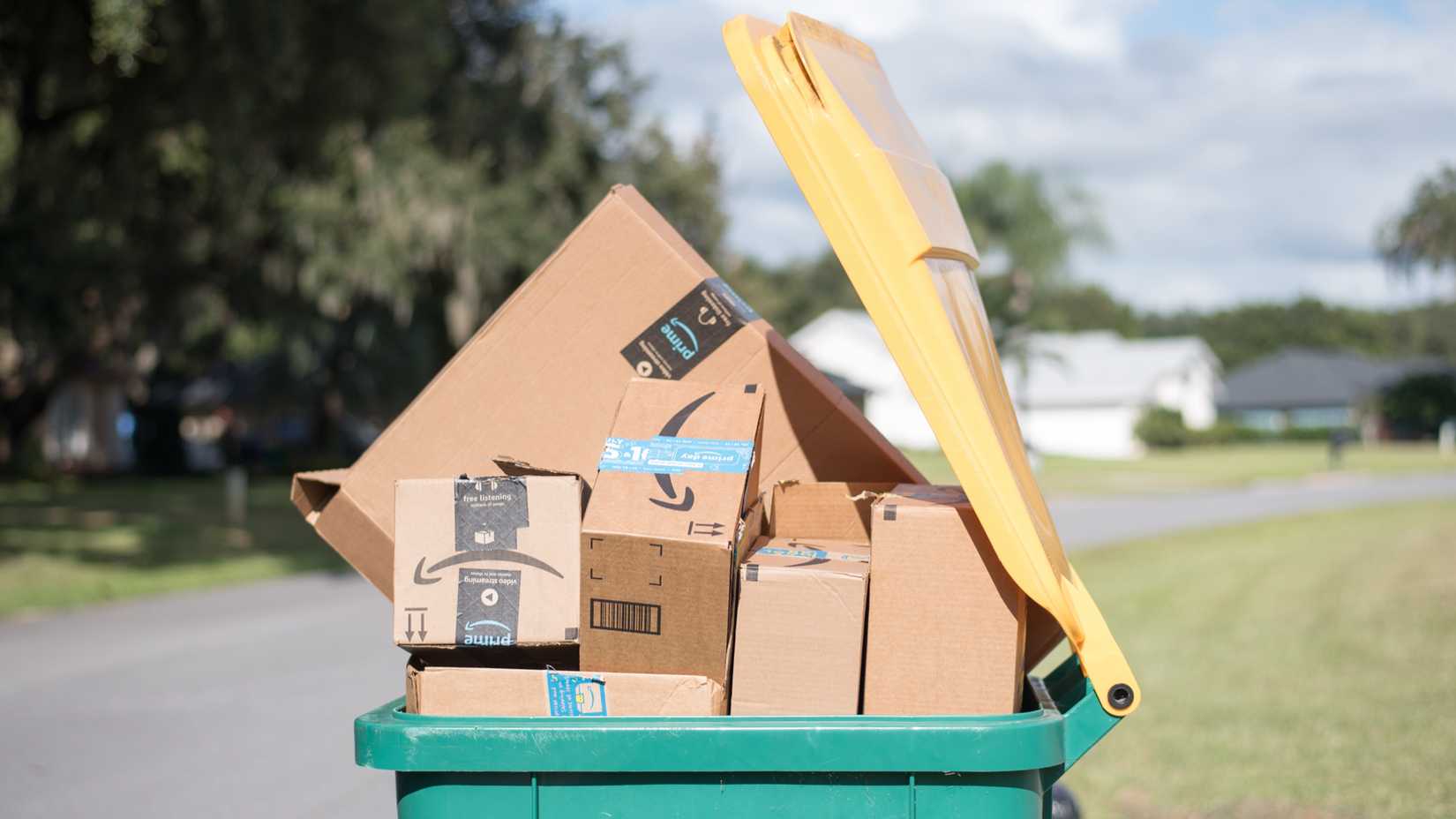 Amazon boxes stacked in a trash can. 