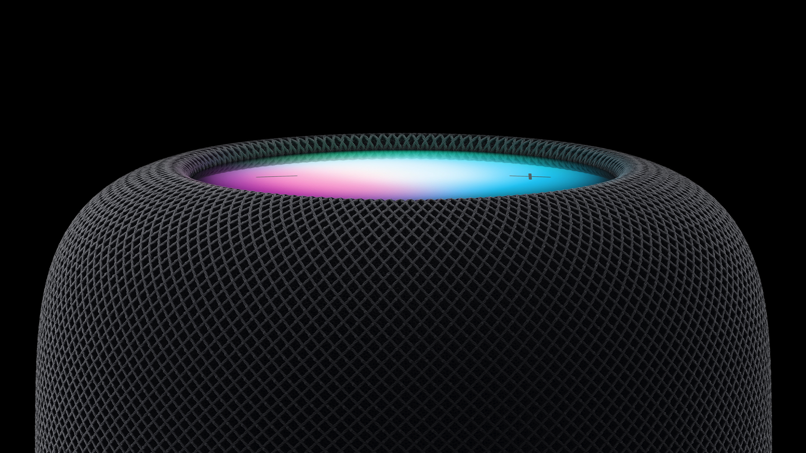 Black HomePod in front of a black background.