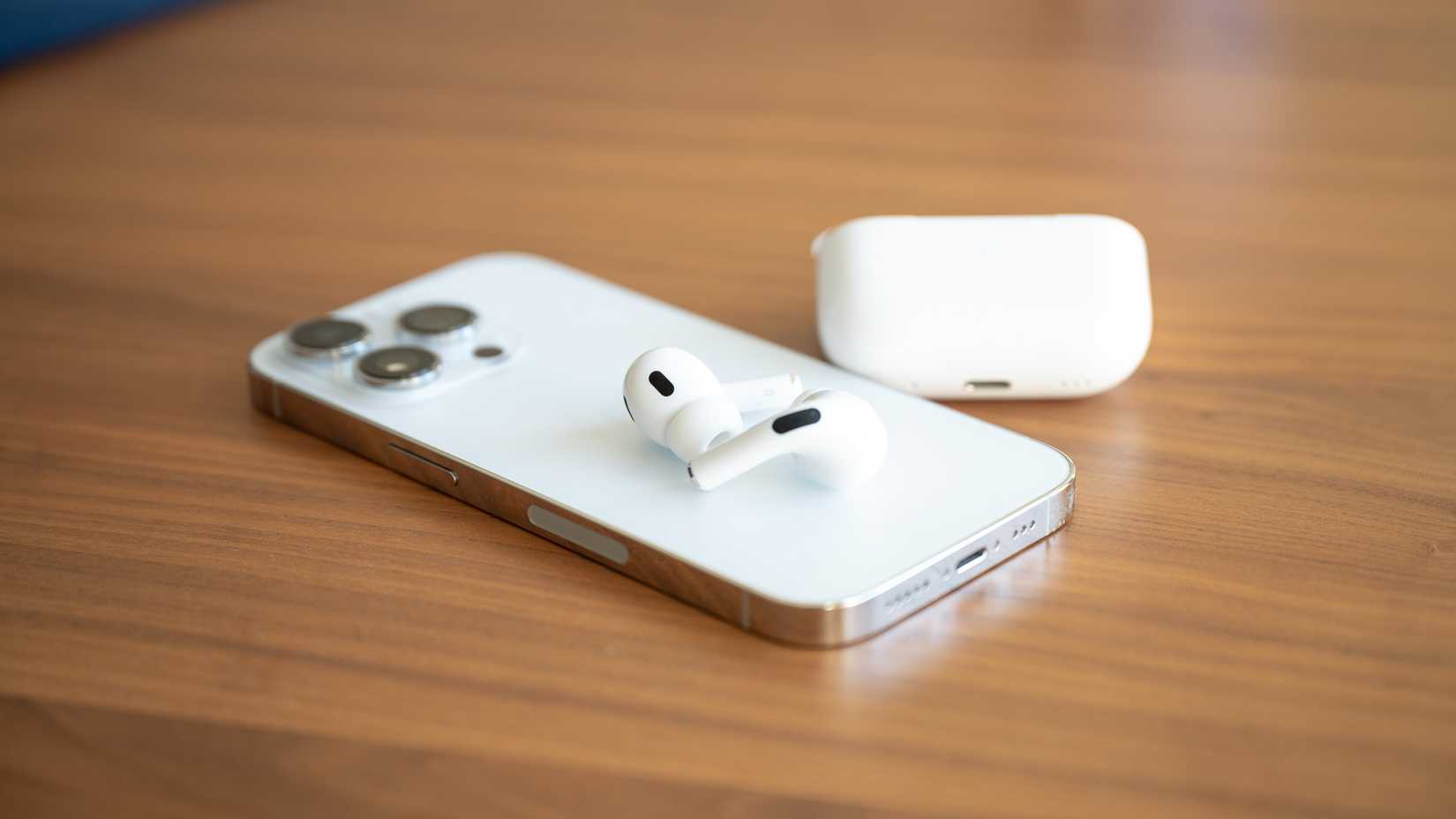 Apple iPhone 14 Pro with AirPods Pro 2nd Gen sitting on the back