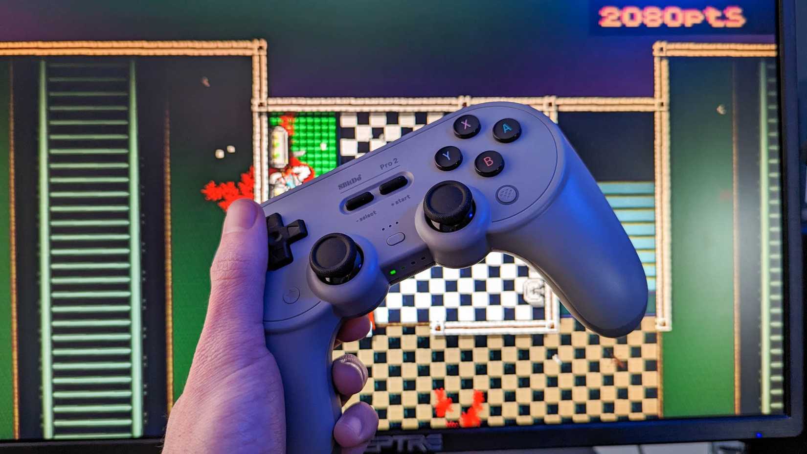 8Bitdo Pro 2 wireless controller with a computer monitor