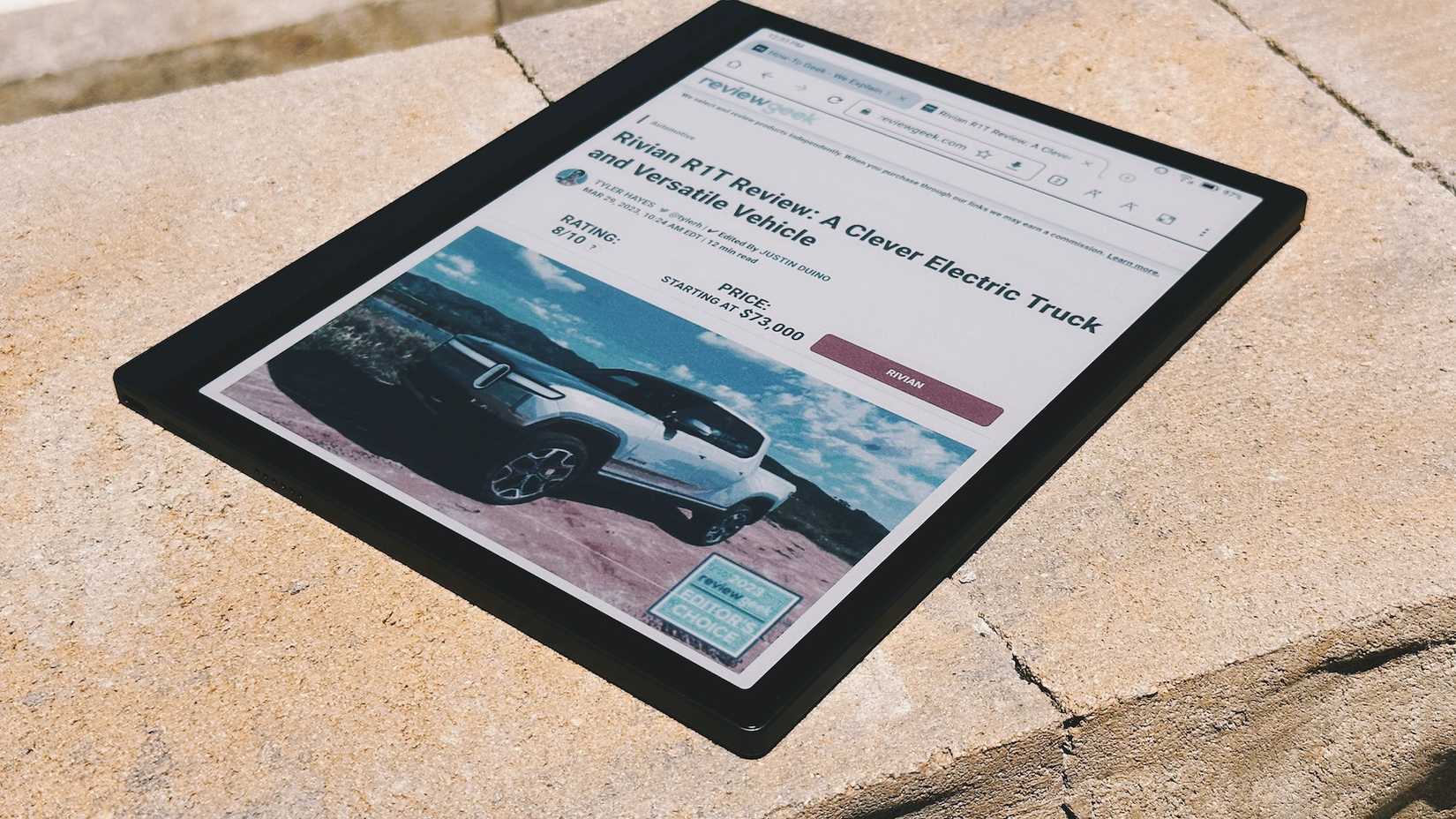 Boox Tab Ultra C ao ar livre sob luz solar intensa mostrando um site.