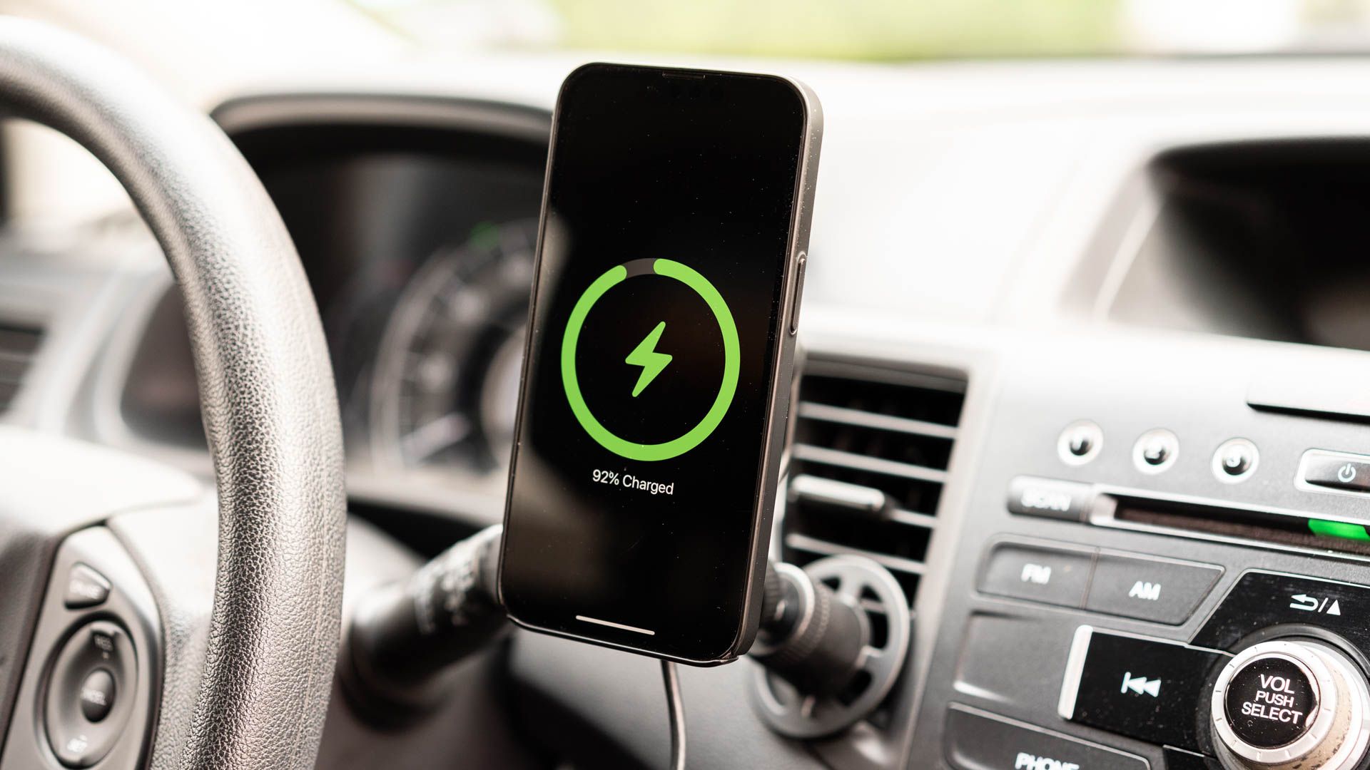 An iPhone charging on the mophie Wireless Charging Vent Mount with MagSafe.