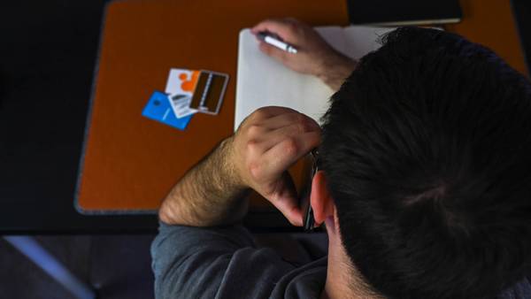 Person on the phone with a stack of cards infront of him as part of a scam