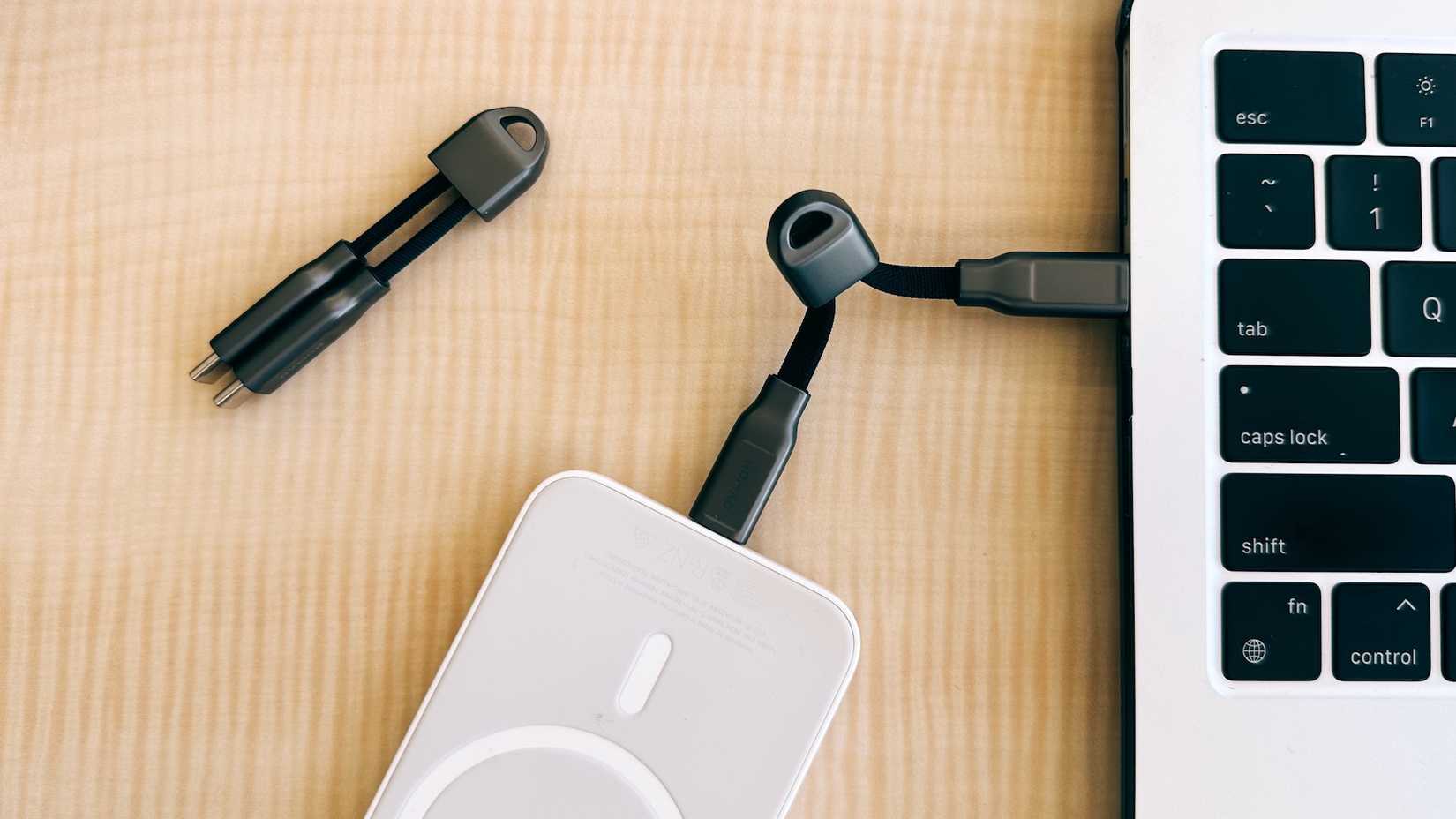 A Nomad ChargeKey cable plugged into a battery and a MacBook Air.