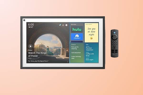 Amazon Echo Show and remote on a peach colored background.