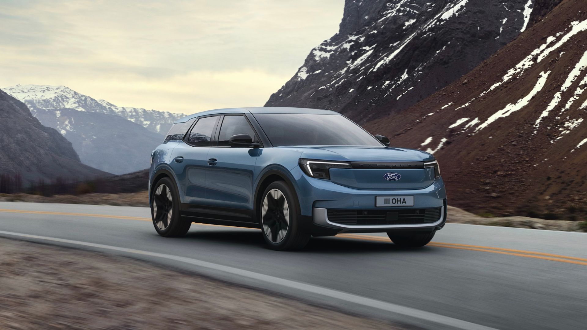 all-electric Ford Explorer driving on a road in the mountains. 