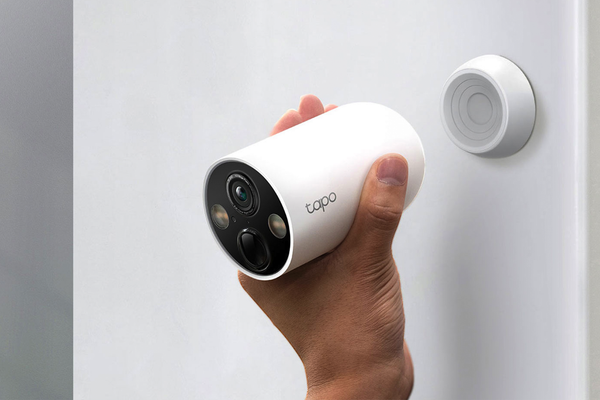 Detaching the TP-Link Tapo Wire-Free Security Camera from its magnetic base for charging.