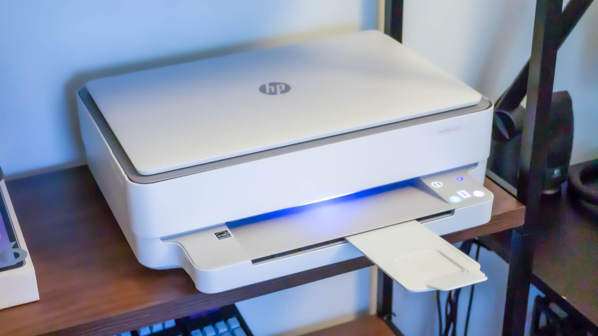 An HP Envy 6055e home printer on a shelf.