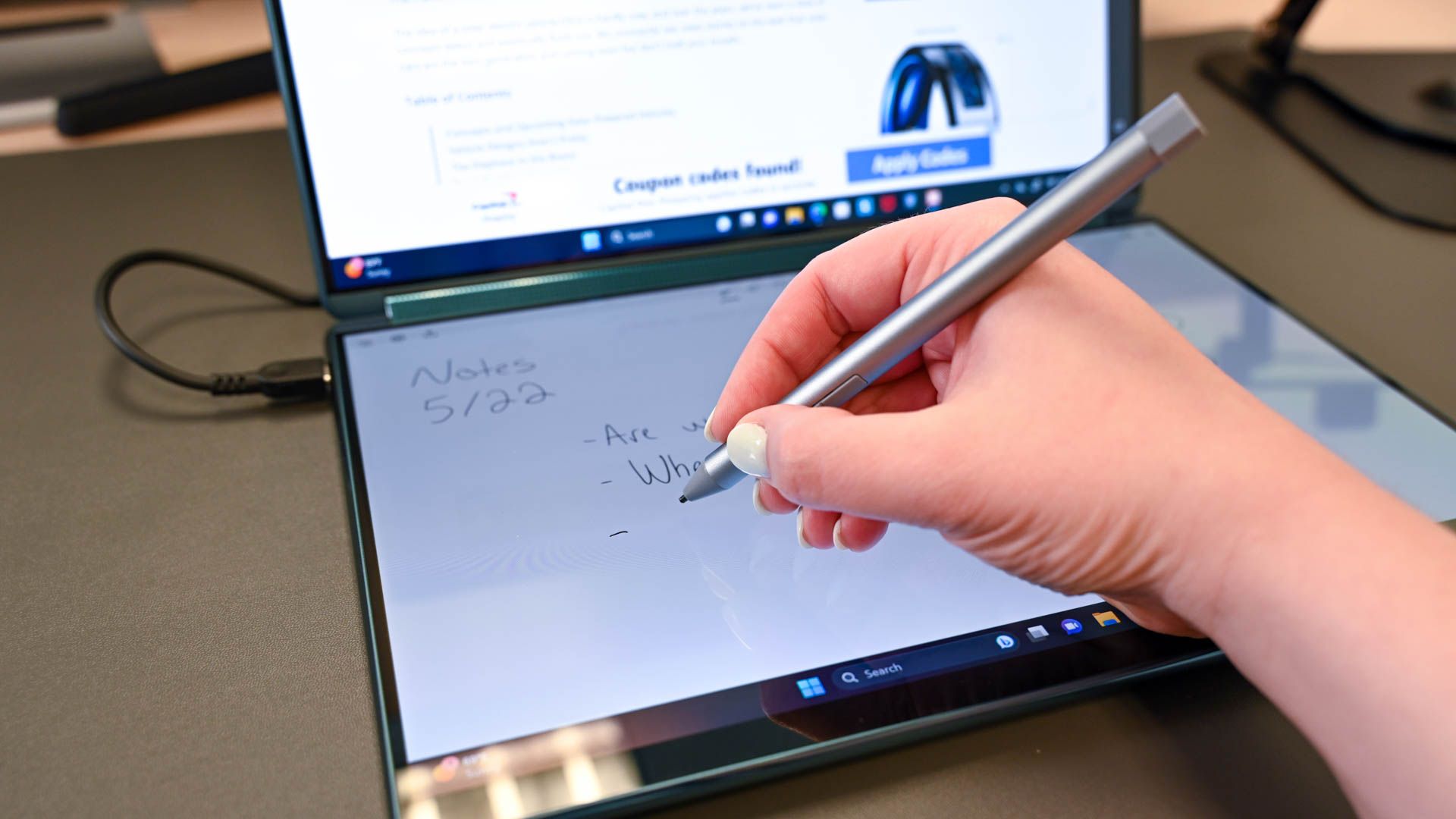 Person using the Lenovo Yoga Book 9i pen to take notes