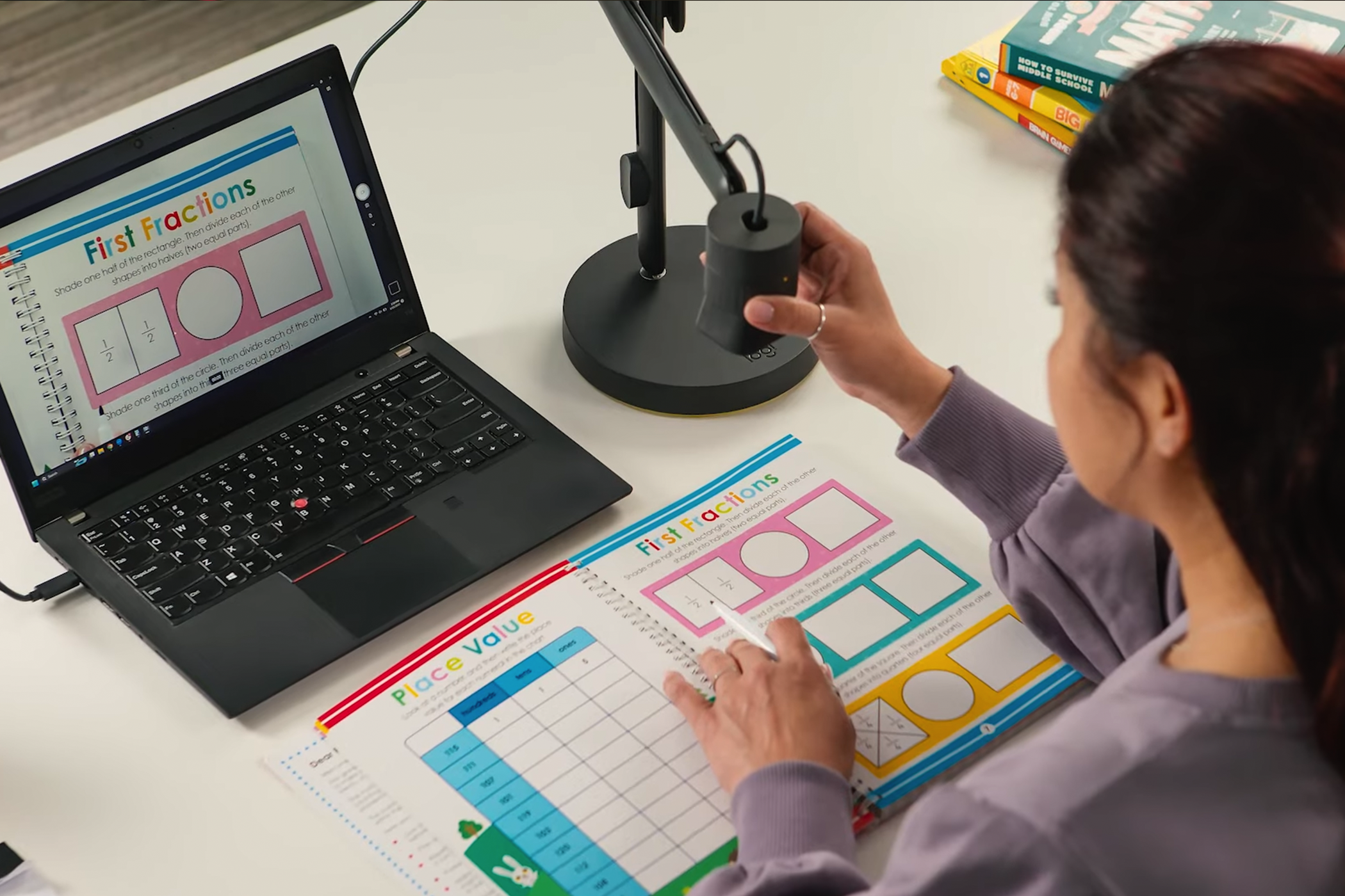 Educator using the Logitech Reach Overhead Webcam to stream a workbook to students.