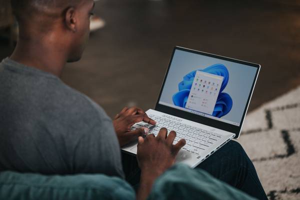 person working on Windows 11 computer on the couch