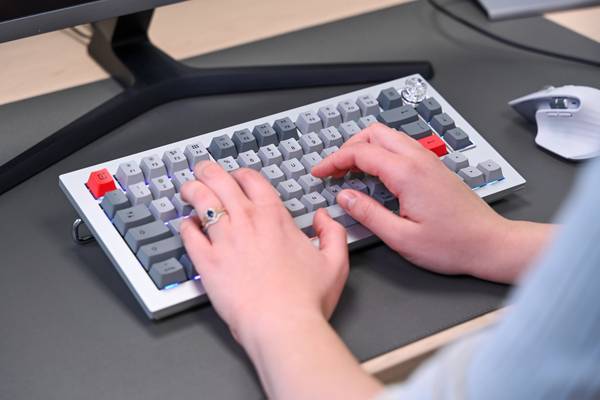 Person typing on the OnePlus Keyboard 81 Pro with rainbow backlighting.