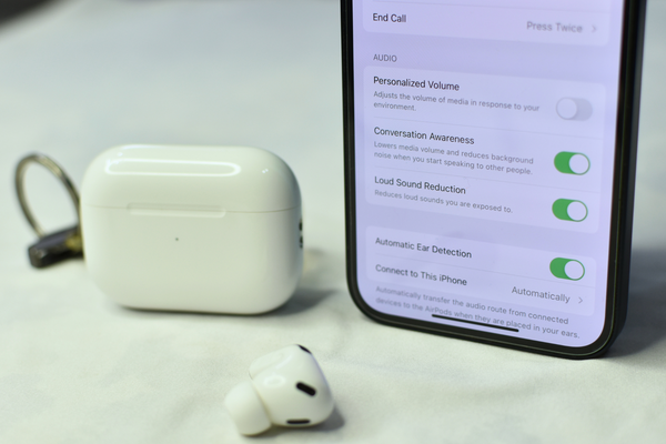 AirPods Pro and iPhone kept side by side on a white surface