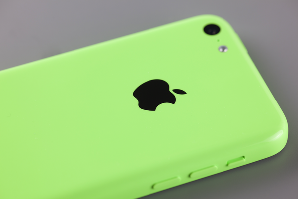 A green iPhone 5c on a table.