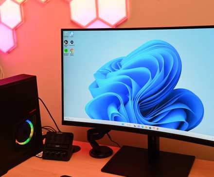 A Windows 11 computer placed on a table close to a speaker.