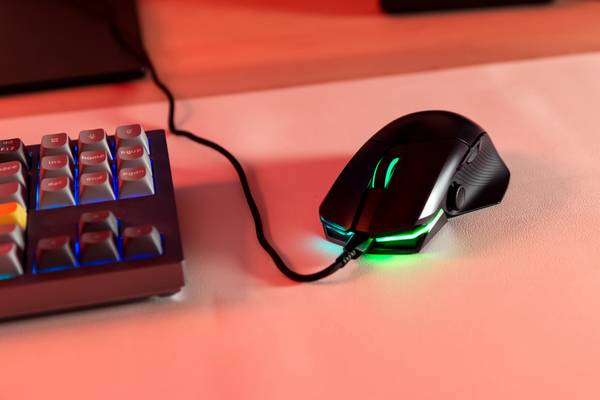 A mouse with green lighting on a table. 