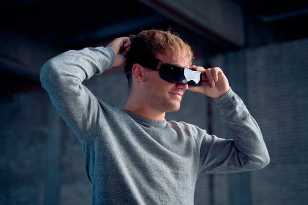 A man adjusting a Bigscreen Beyond VR headset on his head.