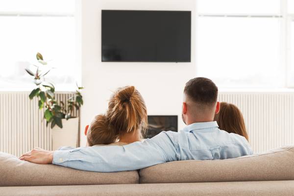 A TV mounted in a too high position above a fireplace.