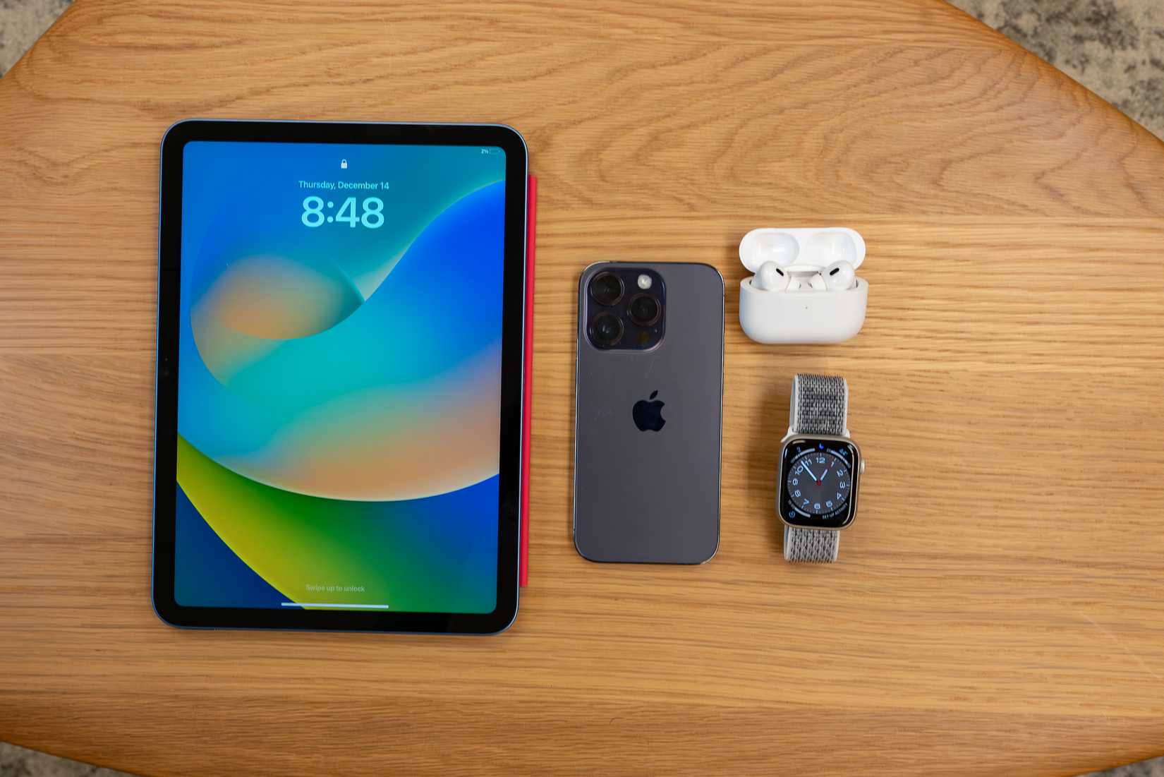 Vista superior do iPAd Pro, iPhone 14, Apple Watch e Airpods