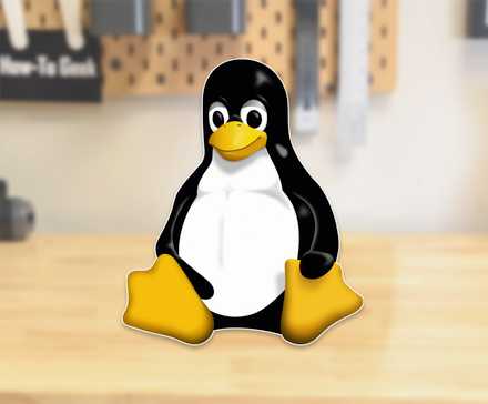 The Linux mascot, Tux, sitting on a workbench.