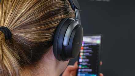 Person listening to music using a pair of Bose QuietComfort Ultra Headphones.