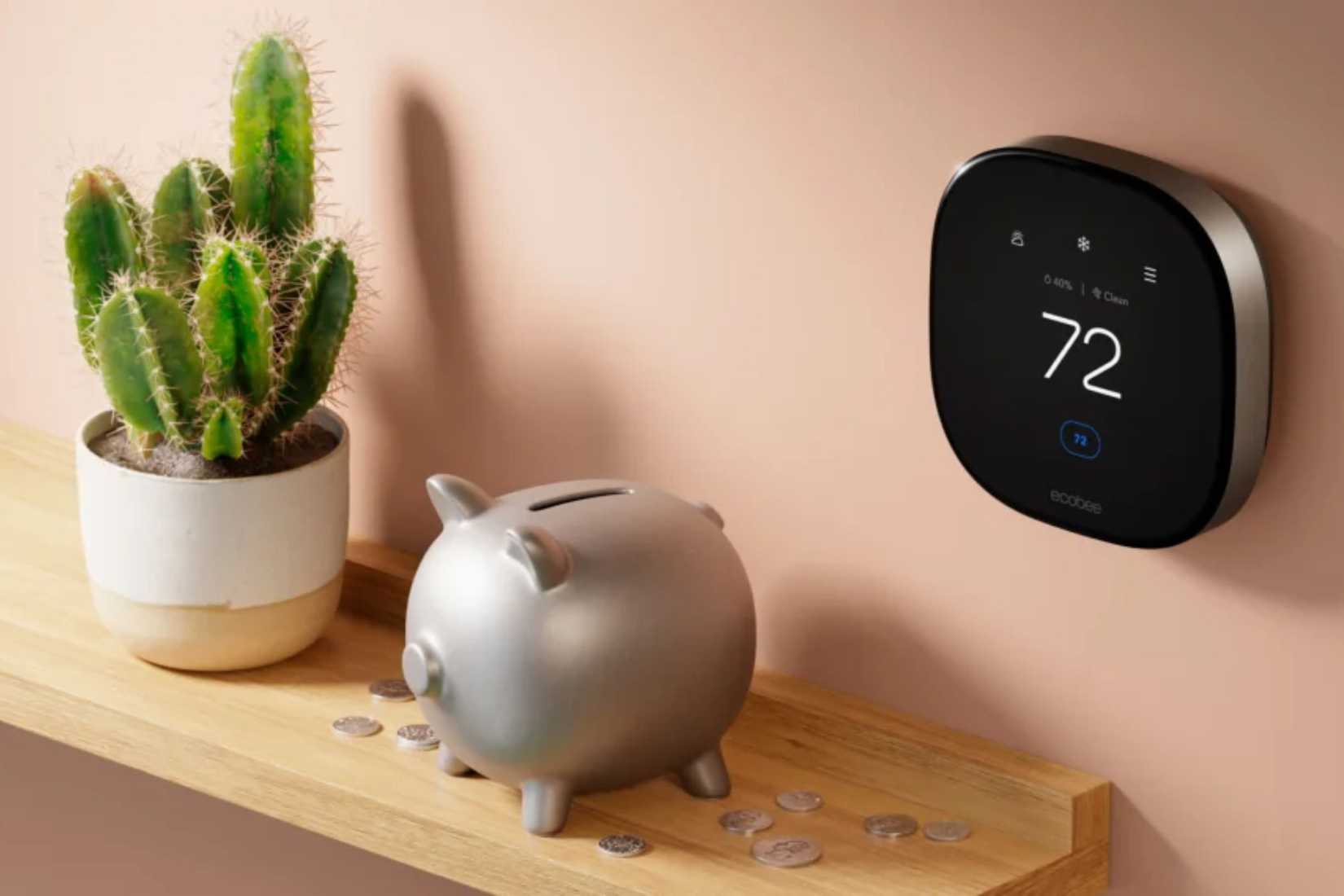 Ecobee Smart Thermostat Premium instalado ao lado de um cofrinho e um cacto.