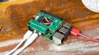 Raspberry Pi computer on a wooden surface with cables connected.