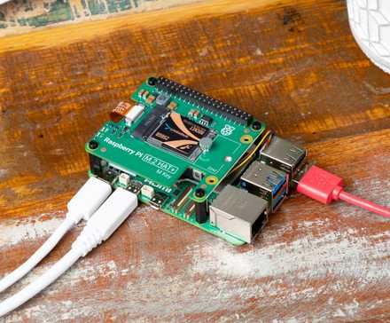 Raspberry Pi computer on a wooden surface with cables connected.